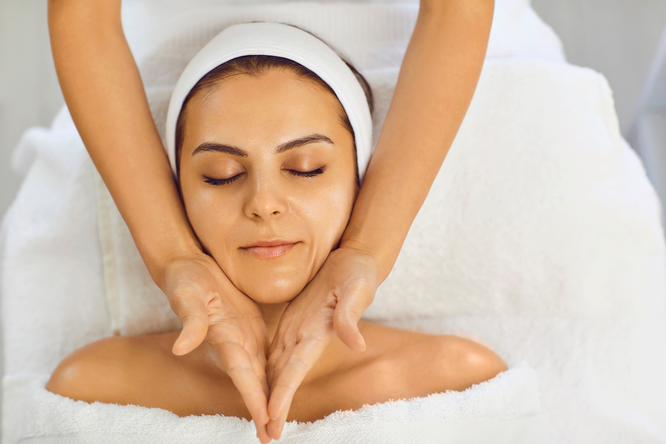 Young Woman Receiving Facial Massage at the Salon Kosmetalogicheskom. Facial Skin Care.